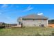 View of backyard featuring new brick home with black metal fence on a sunny day at 3054 Constitution Ln, Gastonia, NC 28056