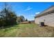 View of backyard featuring new brick home with lawn and trees on a sunny day at 3054 Constitution Ln, Gastonia, NC 28056