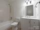 Bright bathroom with a tub and shower, white vanity, toilet and neutral tile floor at 3709 Willow Point Dr, Charlotte, NC 28277