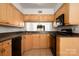 Cozy kitchen featuring tile floors, wood cabinets, and black appliances at 3709 Willow Point Dr, Charlotte, NC 28277