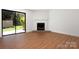 Bright living room with hardwood floors, fireplace, and large window offering backyard views at 3709 Willow Point Dr, Charlotte, NC 28277