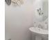 Small bathroom with white pedestal sink, round mirror, and decorative wall art at 3718 Speer Blvd, Charlotte, NC 28217
