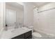 Bright bathroom with marble countertops, modern fixtures, and combined tub and shower with white tile at 3718 Speer Blvd, Charlotte, NC 28217