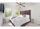 Bedroom featuring a comfortable bed with a tall headboard, two windows, and stylish side tables at 3718 Speer Blvd, Charlotte, NC 28217