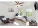 Cozy bedroom with two windows, ceiling fan, and comfortable seating area with an accent chair at 3718 Speer Blvd, Charlotte, NC 28217
