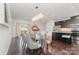 Dining room with modern chandelier, chairs, table, kitchen island and stainless appliances at 3718 Speer Blvd, Charlotte, NC 28217