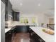 Spacious kitchen with dark cabinets, quartz counters, a center island, and stainless steel appliances at 3718 Speer Blvd, Charlotte, NC 28217
