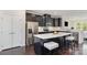 Modern kitchen features dark cabinetry, stainless steel appliances, and a quartz-topped island with seating at 3718 Speer Blvd, Charlotte, NC 28217