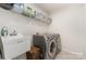 Laundry room features washer, dryer, utility sink, and upper shelving for storage at 3718 Speer Blvd, Charlotte, NC 28217