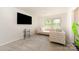 Cozy living room featuring a plush sofa, large TV, and natural light from nearby windows at 3718 Speer Blvd, Charlotte, NC 28217