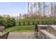 Landscaped backyard with well-maintained green lawn, mature trees, stone-paved patio, and fence at 423 Granite Lake Ct, Denver, NC 28037
