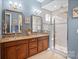 Bathroom featuring double vanity, walk-in shower with glass doors, and modern fixtures at 423 Granite Lake Ct, Denver, NC 28037
