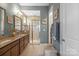 Bathroom featuring double vanity, walk-in shower with glass doors, and a neutral color palette at 423 Granite Lake Ct, Denver, NC 28037