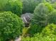 Overhead view of a home surrounded by lush mature trees, a well-maintained lawn, and paved driveway at 4646 Eagle Pointe Ct, Denver, NC 28037