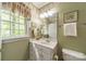 Charming bathroom with floral wallpaper, white vanity, and a large window bringing in natural light and refreshing outside view at 4646 Eagle Pointe Ct, Denver, NC 28037