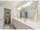 Bathroom with dual sinks, decorative floral wallpaper, and an adjacent toilet room at 4646 Eagle Pointe Ct, Denver, NC 28037