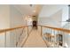 Upstairs hallway with carpet, white railing, and access to multiple rooms at 4646 Eagle Pointe Ct, Denver, NC 28037