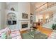 Bright living room featuring a fireplace, built-in shelving, and a view of the staircase at 4646 Eagle Pointe Ct, Denver, NC 28037