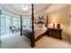 Spacious bedroom with a four-poster bed, sitting area, and large windows at 4646 Eagle Pointe Ct, Denver, NC 28037