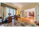 Bright office with a large window, wooden desk, and adjoining formal dining room at 4646 Eagle Pointe Ct, Denver, NC 28037