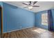 Bedroom with blue walls, ceiling fan, wood floor, and a window with natural light at 4793 Appaloosa Ln, Maiden, NC 28650