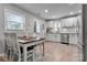 Bright kitchen features white cabinets, stainless steel appliances, and dining area at 501 S Inman Ave, Bessemer City, NC 28016