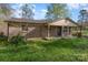 A classic brick home featuring a covered porch, with a quaint and inviting front yard and carport at 518 W Westview St, Gastonia, NC 28052