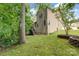 Landscaped backyard with mature trees, lush lawn, and exterior view of the home with access to deck and porch at 6414 Winding Creek Ln, Denver, NC 28037