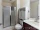 Cozy bathroom with tiled floors, a glass shower door, and white cabinet at 6414 Winding Creek Ln, Denver, NC 28037