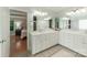 Ensuite bathroom with double vanity, tiled floor, quartz countertops and a peek into the bedroom at 6414 Winding Creek Ln, Denver, NC 28037