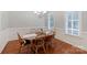 Cozy dining room with a wooden table set for six, complemented by natural light from window at 6414 Winding Creek Ln, Denver, NC 28037