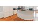 Kitchen featuring an island with stone countertops and white cabinets; hardwood floors throughout at 6414 Winding Creek Ln, Denver, NC 28037