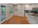 Bright kitchen with hardwood floors, white cabinets, and an island counter with bar seating at 6414 Winding Creek Ln, Denver, NC 28037