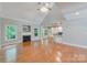 Living room with fireplace, hardwood floors and attached kitchen space with breakfast bar at 6414 Winding Creek Ln, Denver, NC 28037