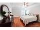 Bright bedroom features a trey ceiling, hardwood floors, large windows, and a decorative accent pillow at 6414 Winding Creek Ln, Denver, NC 28037