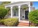 Charming front porch featuring brick steps, white columns, hanging ferns, and a dark-colored front door with a wreath at 6603 Park Meadows Pl, Huntersville, NC 28078