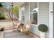 Inviting front porch features wicker rocking chairs, a decorative rug, and potted plants for a relaxing outdoor space at 6603 Park Meadows Pl, Huntersville, NC 28078