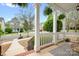 View from the covered front porch of a lovely home with decorative white railings, columns and black iron handrail at 6603 Park Meadows Pl, Huntersville, NC 28078