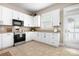 Well-lit kitchen with white cabinetry and stainless steel appliances, with a view of the exterior door at 6603 Park Meadows Pl, Huntersville, NC 28078