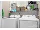 Functional laundry room with modern white appliances and overhead shelving for storage at 6603 Park Meadows Pl, Huntersville, NC 28078