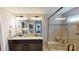 Bright bathroom featuring a dual sink vanity with granite countertops and a tiled walk-in shower at 7016 Butternut Oak Ter, Huntersville, NC 28214