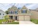 Charming two-story home with stone accents, a well-manicured lawn, and a two-car garage at 7016 Butternut Oak Ter, Huntersville, NC 28214