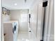 Functional laundry room with modern machines, storage shelves, and neutral color scheme at 7016 Butternut Oak Ter, Huntersville, NC 28214