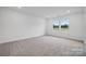 Bright, carpeted bedroom featuring large windows with scenic outdoor views, creating a peaceful atmosphere at 706 Olde England Dr, Lincolnton, NC 28092