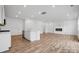 Open-concept living space featuring wood floors, a sleek fireplace, and seamless flow into the modern kitchen at 706 Olde England Dr, Lincolnton, NC 28092