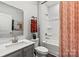 Well-lit bathroom with a tub, shower, gray vanity, framed mirror, and orange towels at 711 Olde England Dr, Lincolnton, NC 28092