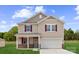 Charming two-story home featuring red window shutters, a front porch, and an attached two-car garage at 711 Olde England Dr, Lincolnton, NC 28092