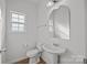 Half-bathroom with pedestal sink, mirror, and a toilet at 7262 April Mist Trl, Huntersville, NC 28078