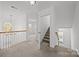 Upstairs hallway features a staircase and a chandelier, offering a glimpse into the adjacent rooms at 7262 April Mist Trl, Huntersville, NC 28078