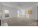 Bright living room with fireplace, plush carpet, and access to dining area and kitchen at 7262 April Mist Trl, Huntersville, NC 28078